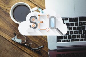 Computador com uma xícara de café e um óculos representando dicas se SEO