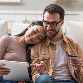 casal-olhando-no-tablet-sentados-no-sofá